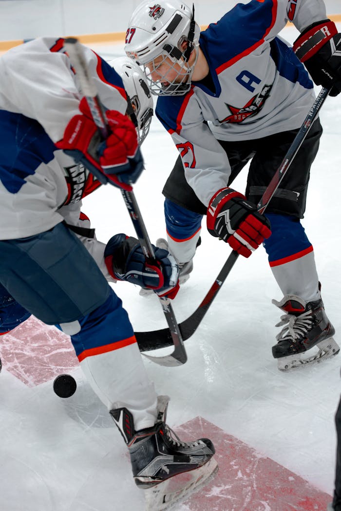 Teenagers in action during an ice hockey match, showcasing teamwork and sportsmanship.
